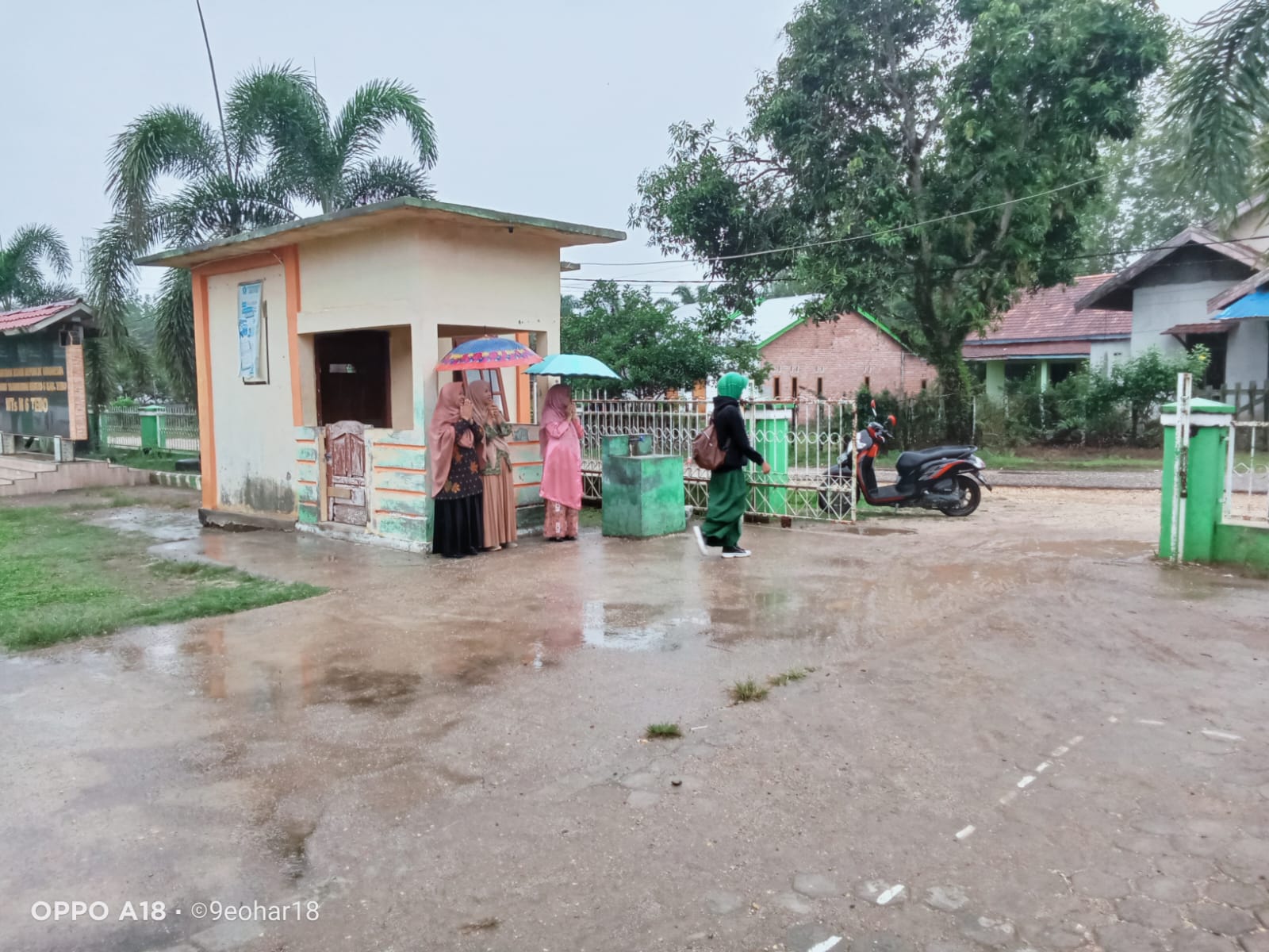 Hujan Bukan Masalah! Aksi Inspiratif Guru Piket di Madrasah Ini Jadi Perbincangan
